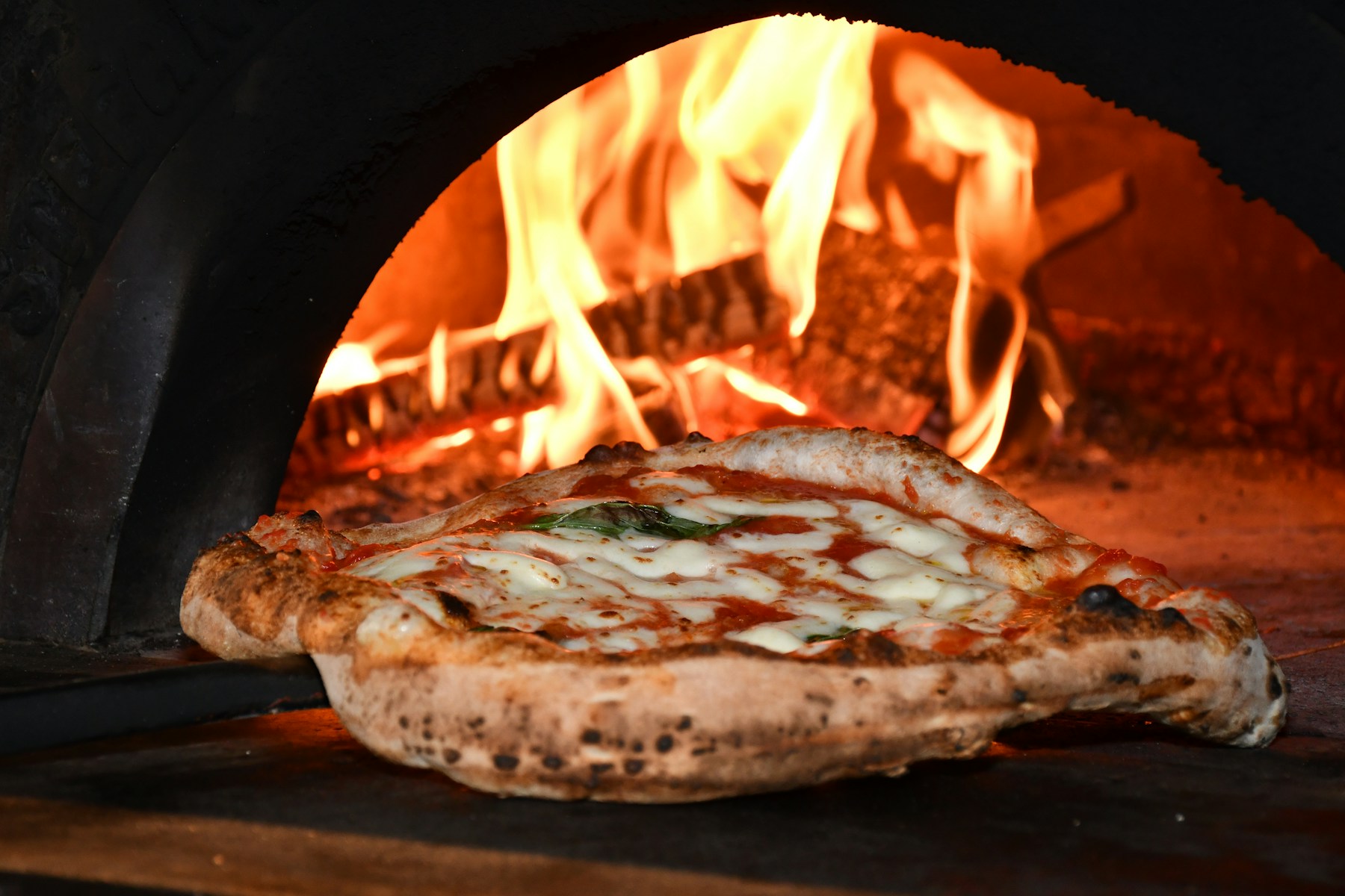 Pizza sortant du four à bois